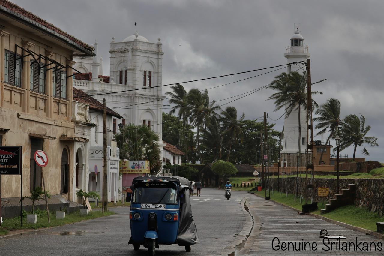 Galle Fort lighthouse and Dutch colonial buildings with a tuk-tuk on the rampart road, UNESCO World Heritage Site, Sri Lanka